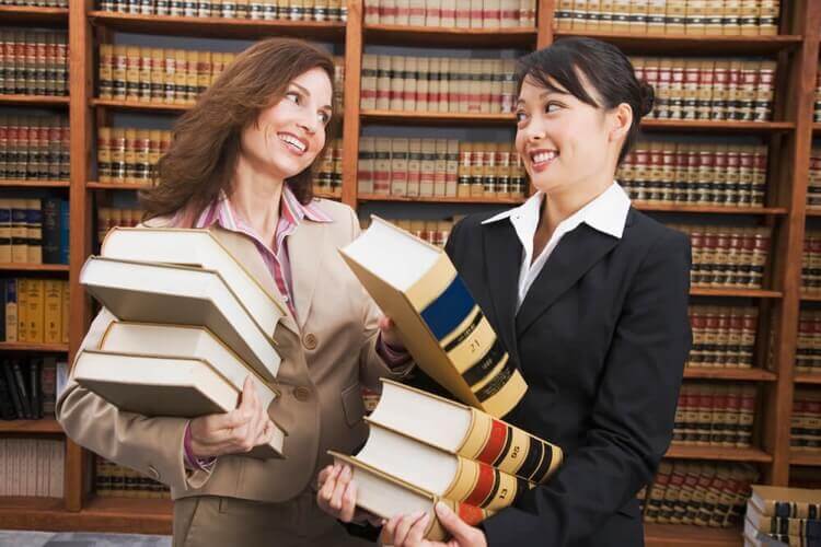 Two female law students in a library.