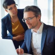 Lawyer working at a computer with coworker looking on