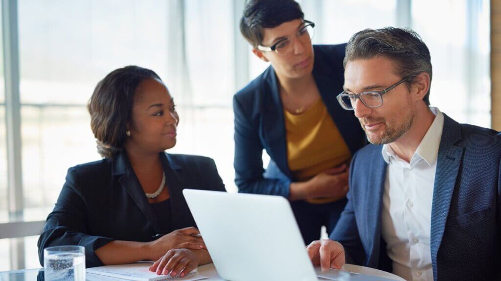 Lawyer working at a computer with coworker looking on